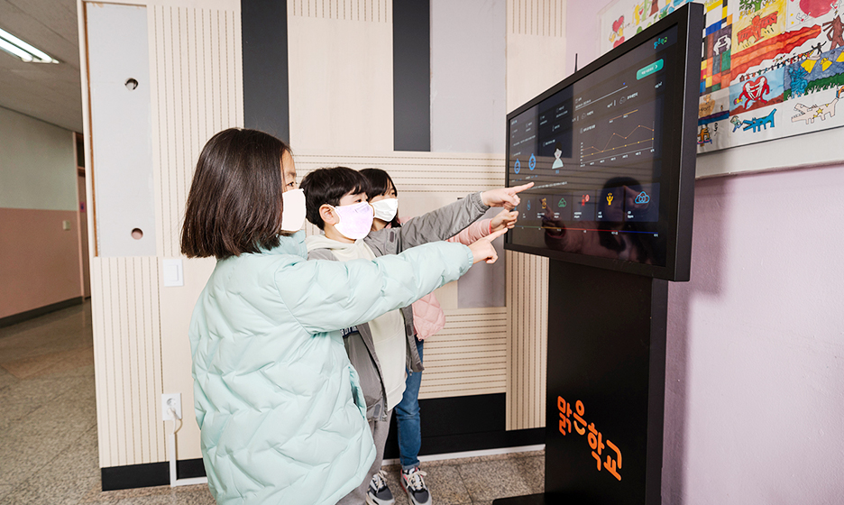 공기질 모니터링 시스템으로 실내 공기청정도를 확인하고 있는 보라매초등학교 학생들