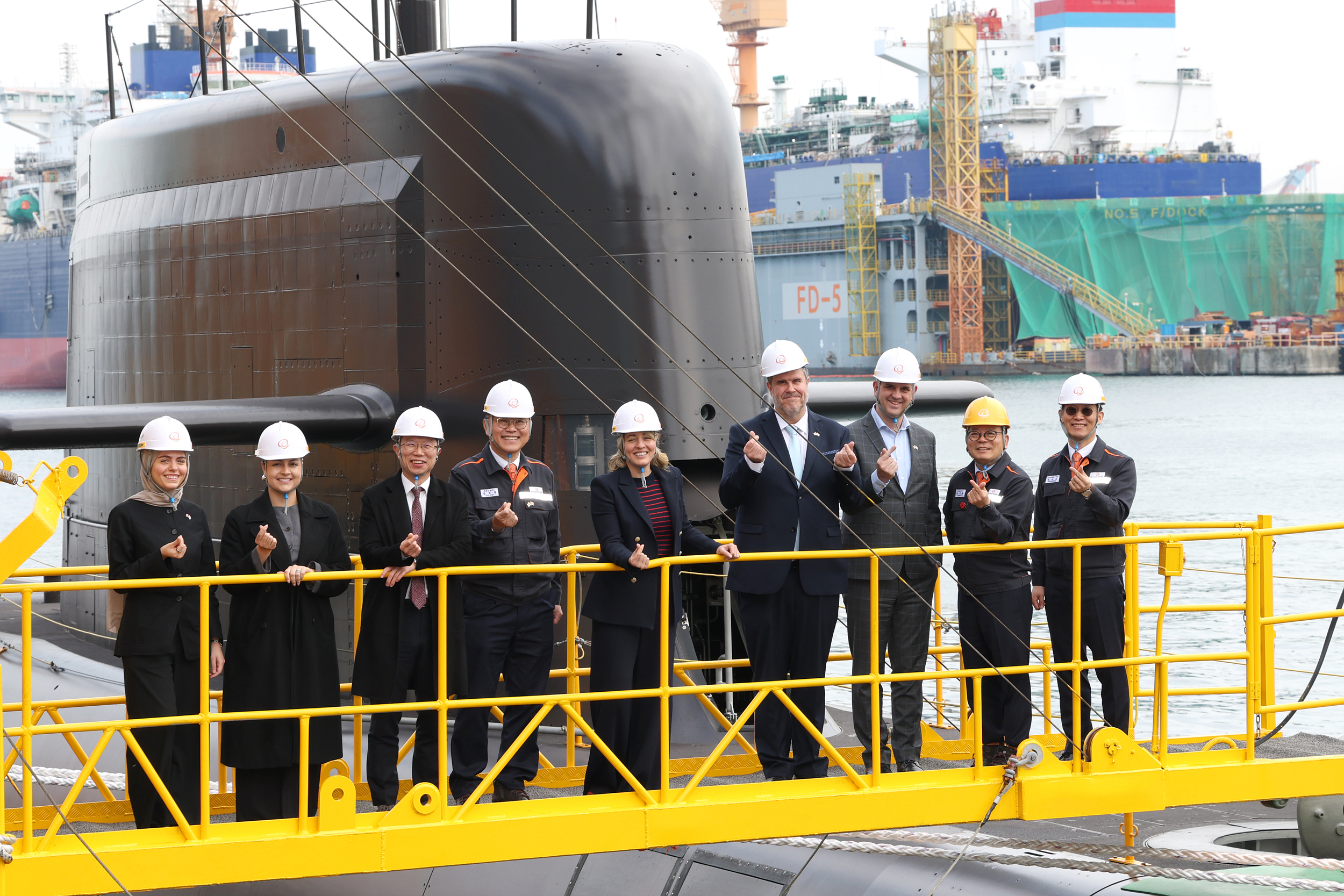 24일 멜라니 졸리 캐나다 산업부 장관(가운데)이 김희철 한화오션 대표이사(왼쪽에서 네 번째), 강환석 방위사업청 차장(왼쪽에서 세 번째) 등과 함께 한화오션이 건조한 잠수함인 장영실함을 배경으로 단체사진을 찍고 있다.