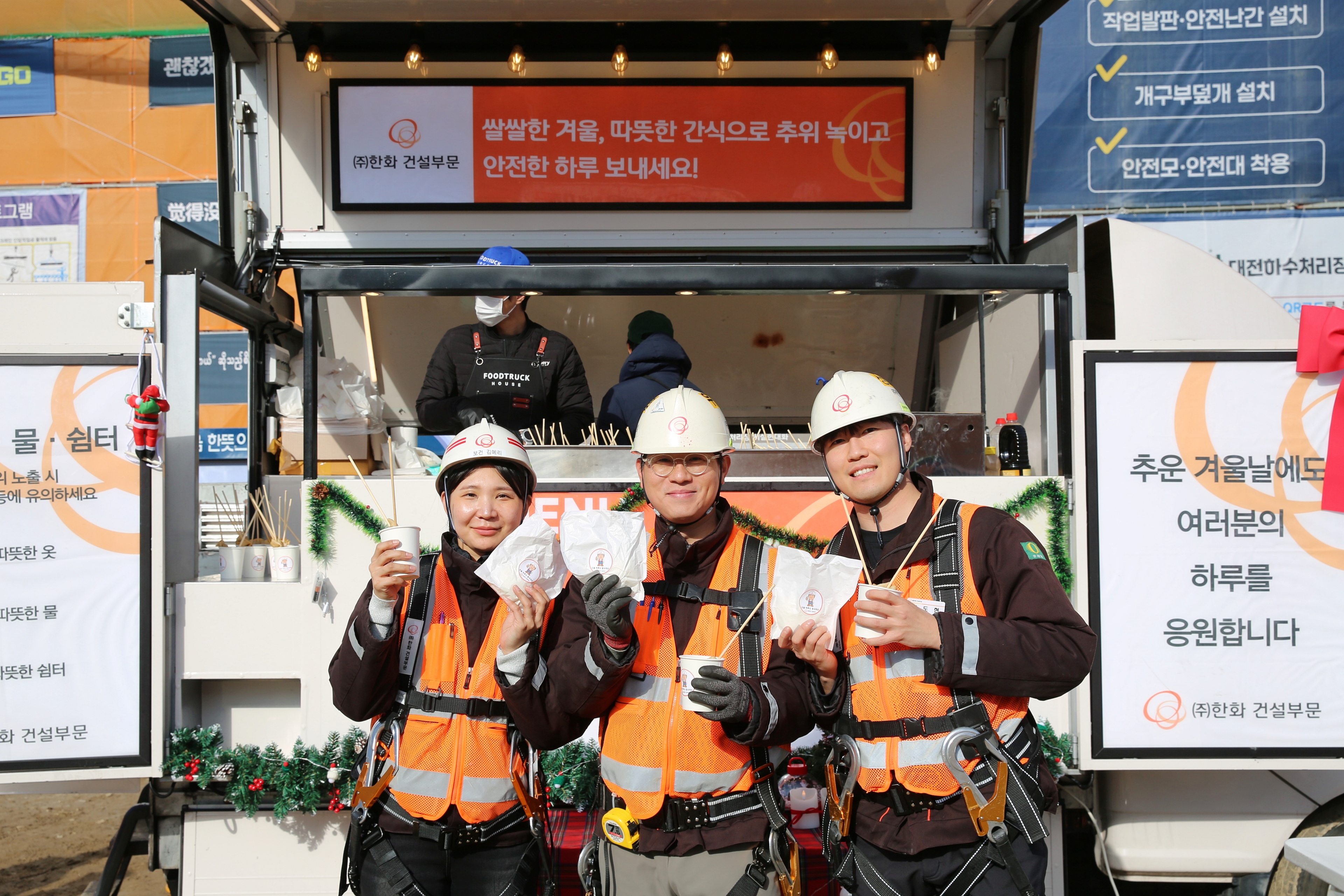 ㈜한화 건설부문 건설현장 근로자들이 ‘찾아가는 겨울간식차’의 호빵과 어묵을 즐기고 있다 