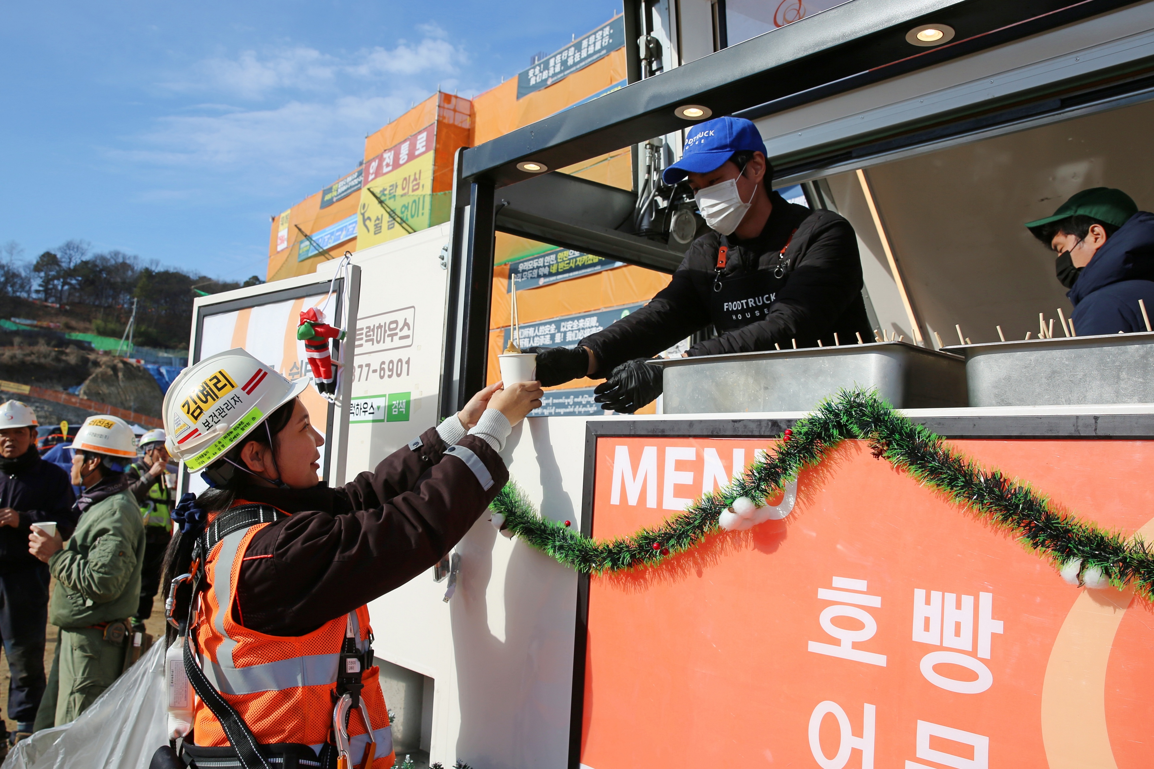 ㈜한화 건설부문 건설현장 근로자들이 ‘찾아가는 겨울간식차’의 호빵과 어묵을 즐기고 있다 